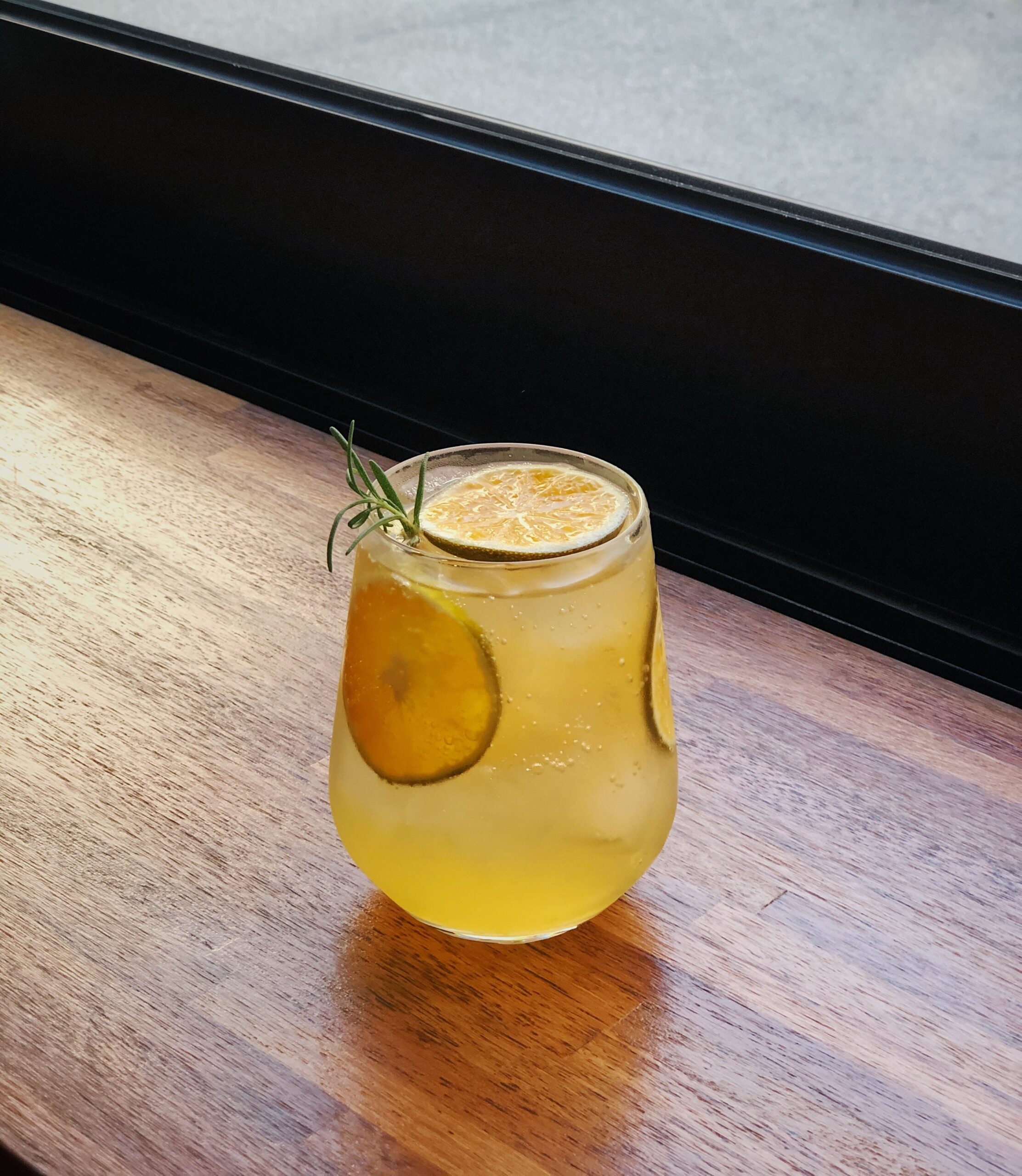limonadă de casă într-un pahar pe o masă, are și două felii de lămâie