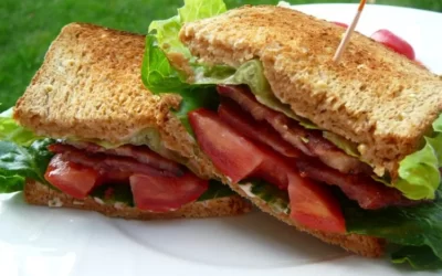 sandwich cu bacon, salată și roșii pe o farfurie