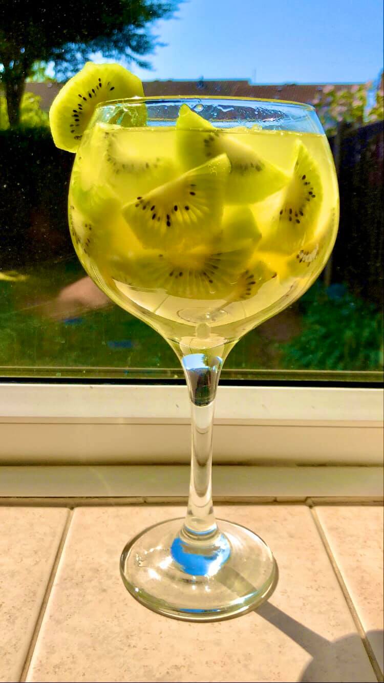 cocktail gin tonic cu kiwi si ananas într-un pahar de bar